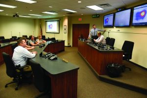 Command staff in board room looking a hot spot maps. 