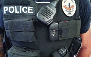 Torso of officer wearing vest with smartphone attached