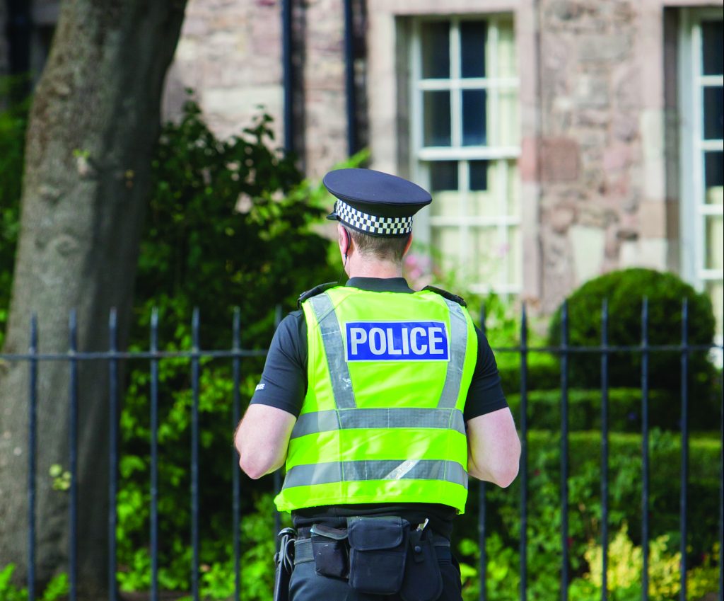 EDINBURGH, SCOTLAND - JULY 21: Police officer on guard duty near the Royal palace. EDINBURGH, SCOTLAND - JULY 21