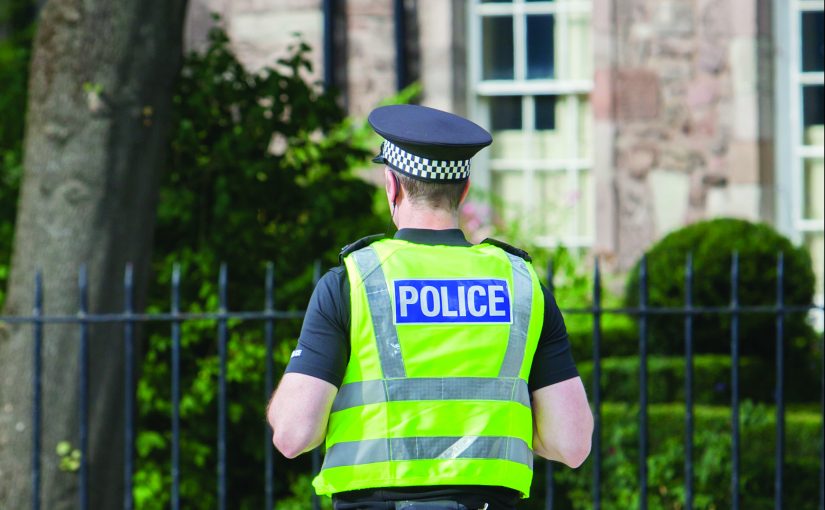 EDINBURGH, SCOTLAND - JULY 21: Police officer on guard duty near the Royal palace. EDINBURGH, SCOTLAND - JULY 21