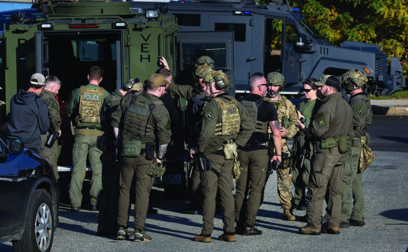 LEWISTON, MAINE - OCTOBER 27: Law enforcement officials gather at the Lewiston High School as they continue a manhunt for suspect Robert Card following a mass shooting on October 27, 2023 in Lewiston, Maine. Police are actively searching for a suspect, Army reservist Robert Card, who allegedly killed 18 people in a mass shooting at a bowling alley and restaurant in Lewiston, Maine.