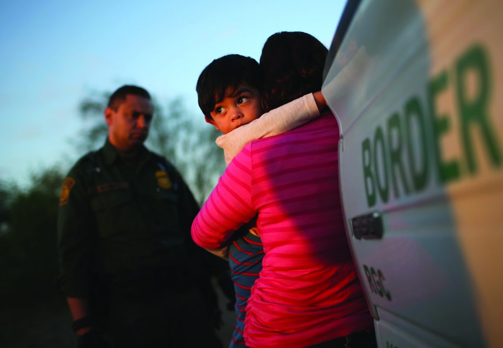 A one-year-old from El Salvador clings to his mother after she turned themselves in to Border Patrol agents on December 7, 2015, near Rio Grande City, Texas.