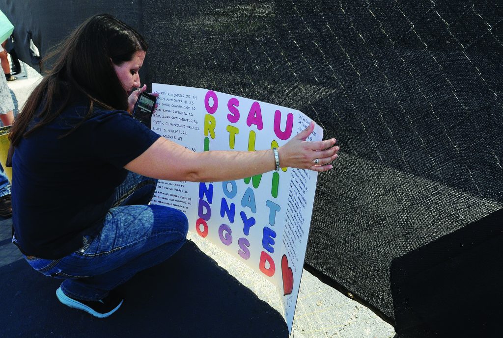 A woman leave a sign for the victims of the Pulse Nightclub shooting at the front of the nightclub building on June 21, 2016 in Orlando, Florida.