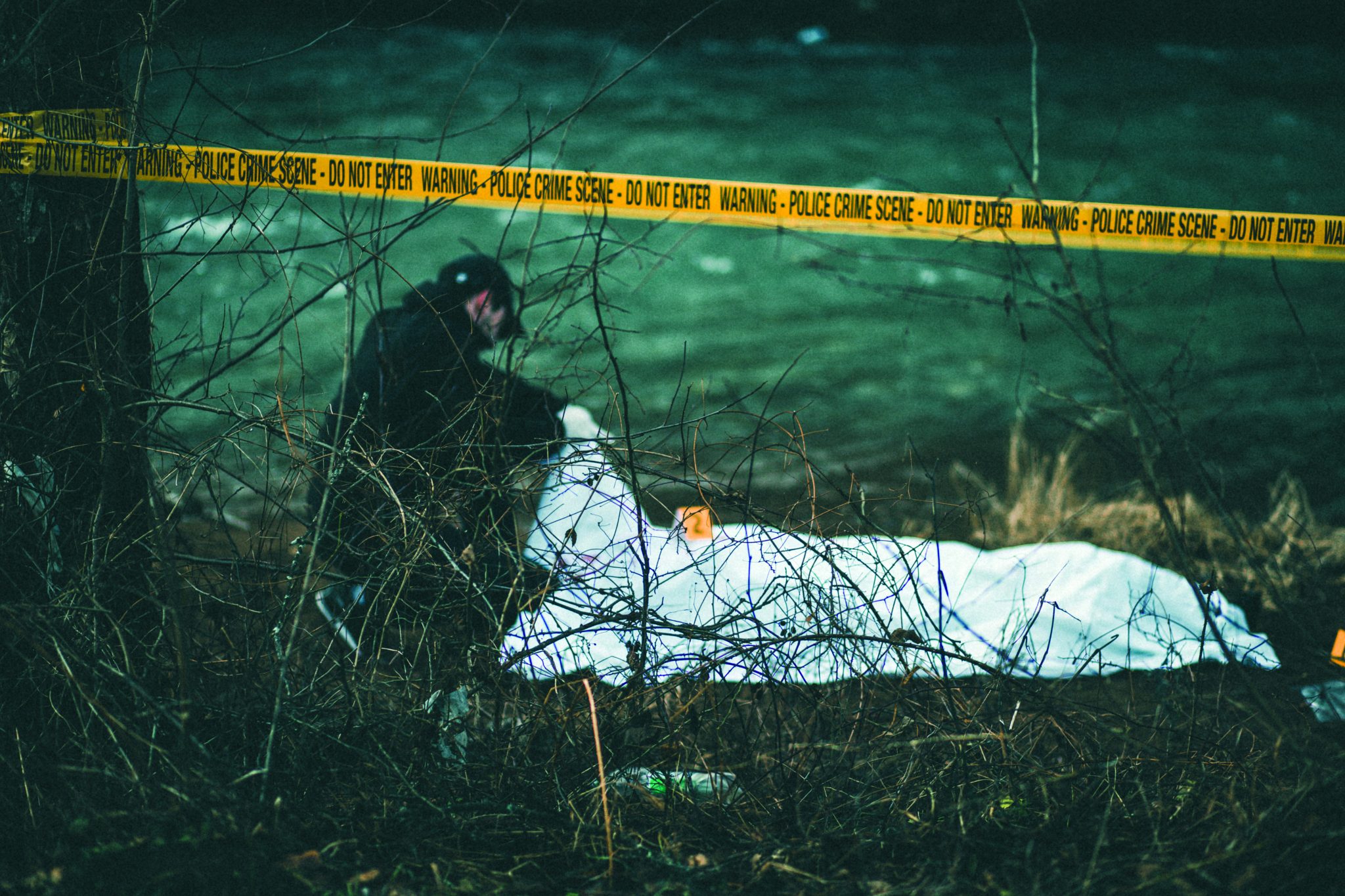 Detective investigating crime scene by the river - Police Chief Magazine