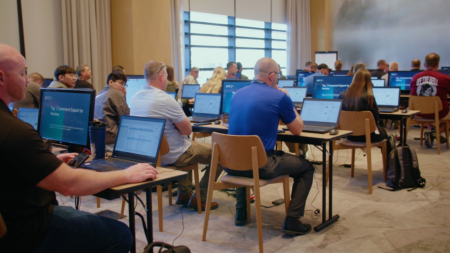 Adults sitting in rows with laptops